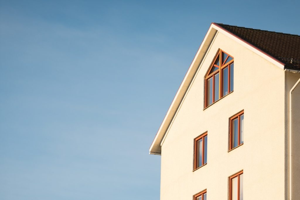 Beige house with red windows against blue sky